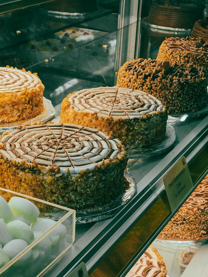 A variety of decorative cakes showcased in a bakery display case, perfect for any celebration.